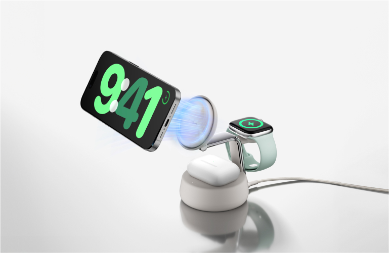 白色 Belkin 3 合 1 無線充電支架正同時為 iPhone、Apple Watch 和 AirPods 充電，圖中顯示手機的磁力對位。
