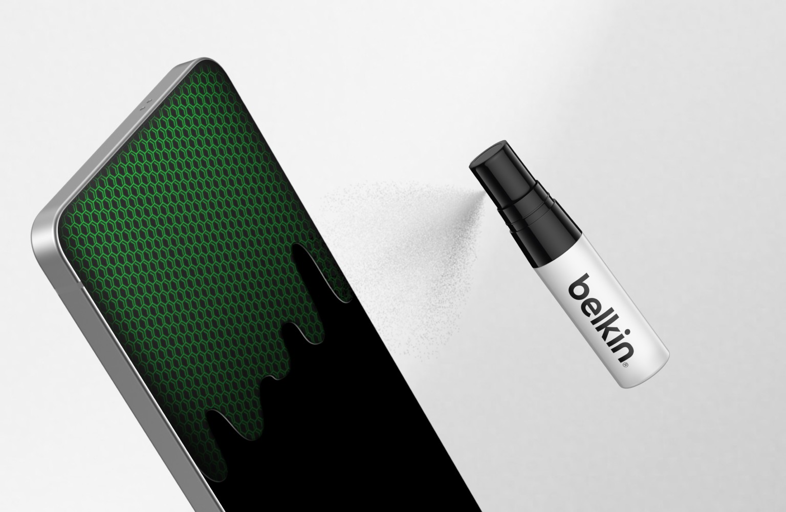 Smartphone display shown with a green hexagonal pattern as a Belkin cleaning spray is applied, illustrating screen cleaning and preparation before protector installation.