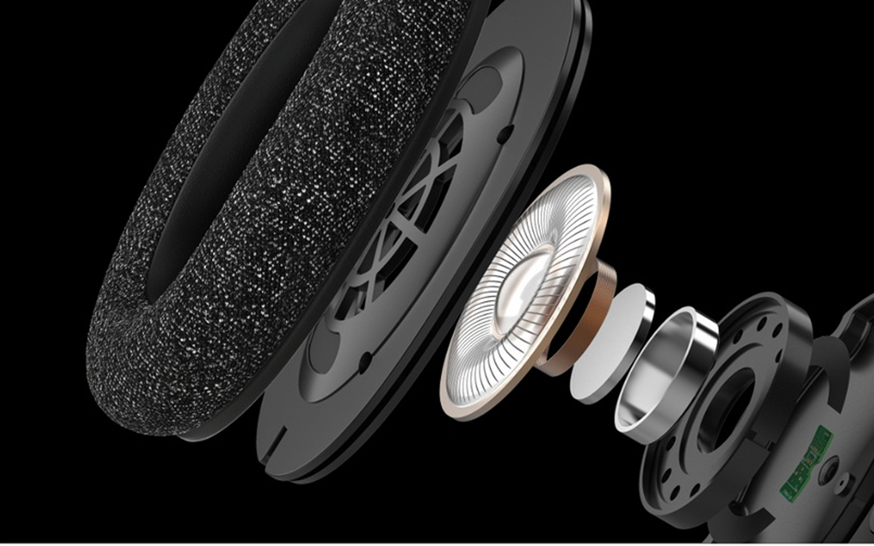 Close-up exploded view of a headphone speaker assembly, showing layered components including an ear cushion, driver diaphragm, voice coil, and magnet against a black background.